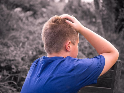 A young boy with blond hair stressing over his tablet.