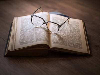 A pair of glasses on top of a book.