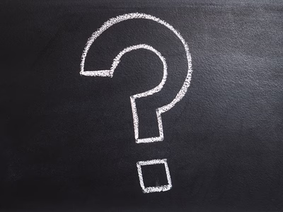 A question mark drawn in chalk on a blackboard.