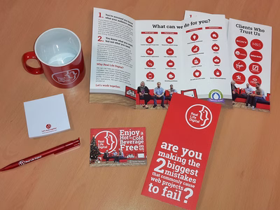 Real Life Digital branded goodies including a mug, some flyers, a notepad, a pen and a free beverage voucher.