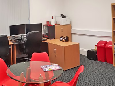 A creative environment with workstations, an informal meeting table and display cabinet.