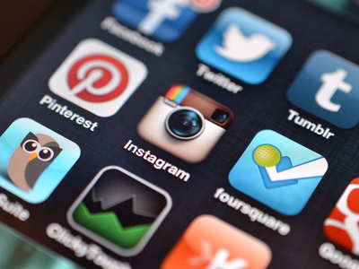 A close up of a phone screen showing the apps menu with lots of social media applications such as facebook, twitter, tumblr, linkedin, pinterest, instagram, foursquare and google+.