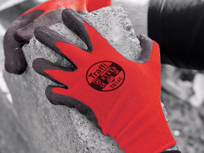 A man wearing a pair of red safety gloves.