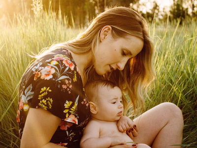 A mother and her baby outside on a warm sunny day.