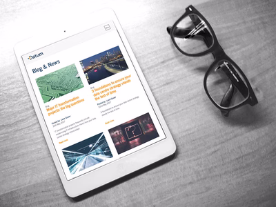 The blog page shown on an Apple iPad which is laid on a desk next to a pair of reading glasses.