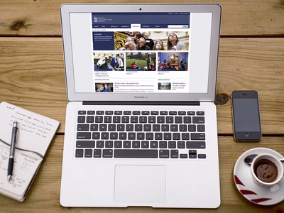 Royal Collection Trust: The Royal Collection Website on an Apple MacBook with a notepad to the left and a phone and coffee cup to the right.