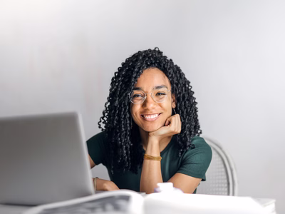 A woman smiling because she is happy she's found the content management software that works for her.