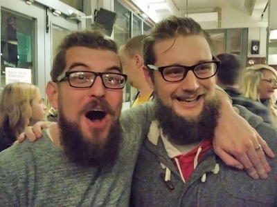 Bart Feenstra and Darren Fisher - two young men with long hair, thick glasses and long beards (who look very similar) at the Saturday night party for DrupalCamp 2016.