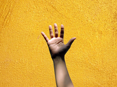 A hand with all four fingers and thumb up signifying '5 of something'" on a yellow gold textured backdrop.