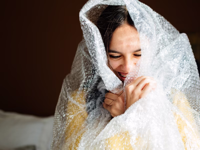 Lady smiling wrapped in bubble wrap