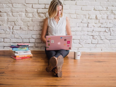 A woman sat on the floor with her laptop.