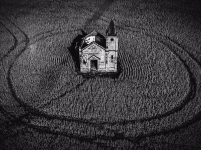 The ruins of a building in the middle of a field.