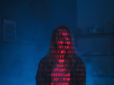 A hacker with red binary code projected on to her face.