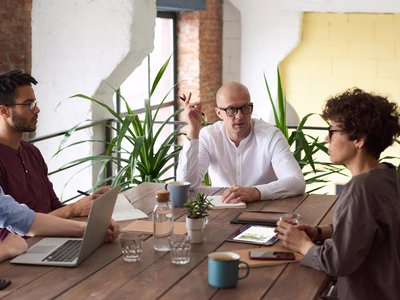 A creative team sitting in a relaxed meeting setting, discussing ideas and collaborating