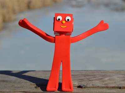 A red robot celebrating with it's arms in the air.