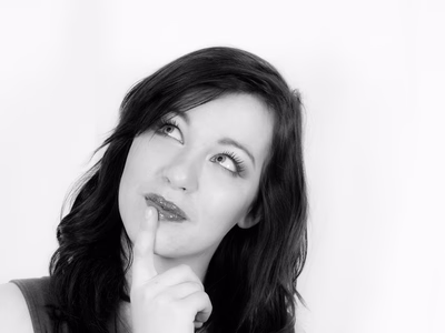 Pensive woman looking up and right inquisitively.