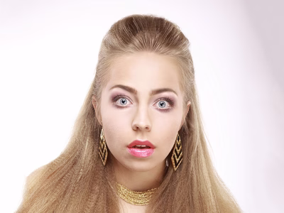 A girl stares wide-eyed in to the camera, looking a little lost, perplexed and confused.