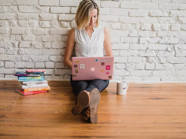 A woman sat on the floor with her laptop.