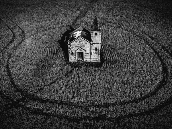 The ruins of a building in the middle of a field.