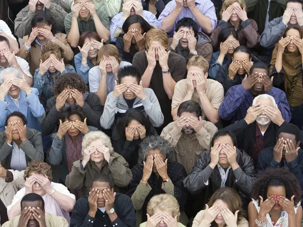 A crowd of people covering their eyes.