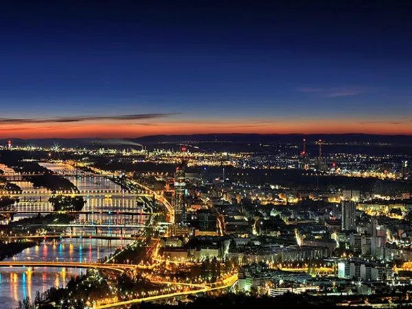 An aerial view of the Danube through Vienna at dusk.