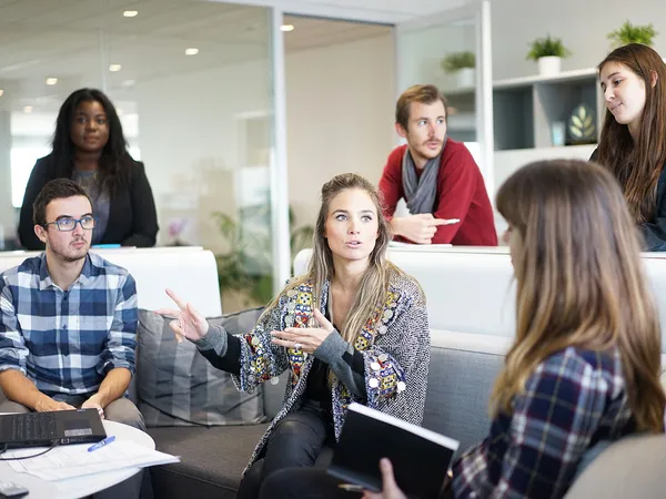 A creative team sitting in a relaxed meeting setting, discussing ideas and collaborating.