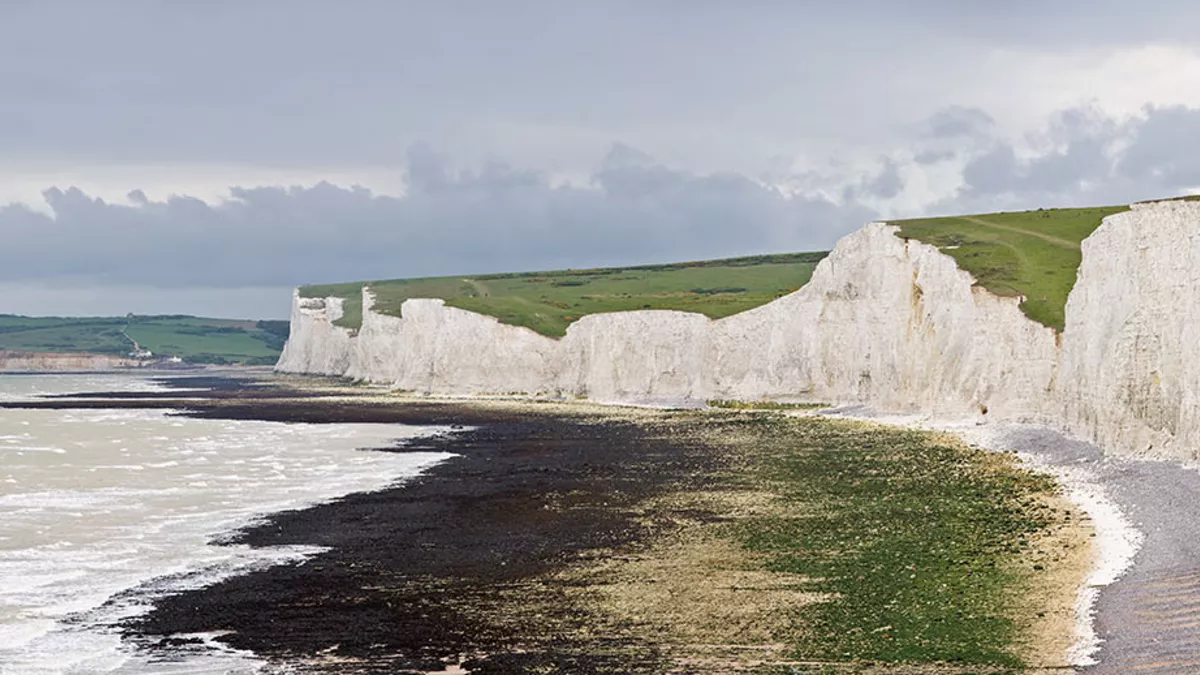 The Seven Sisters, a series of seven chalk cliff peaks along the East Sussex coast in England. Seaford head in the background is on the other side of the River Cuckmere and not part of the Seven Sisters.