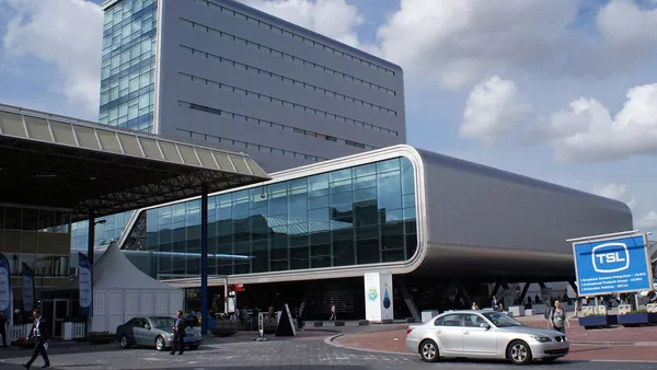 The RAI conference centre situated in the outskirts of Amsterdam; a modern looking building with a long base and tall skyscraper-esque protrusion. The frontage is entirely glass surrounded by a chunky steel exterior.