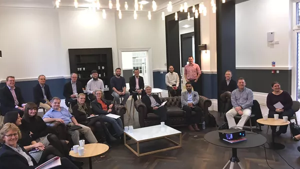 A business lounge with a posed photo of about 20 attendees to the GDPR presentation.