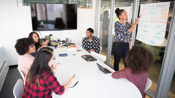 A team meeting taking place in a meeting room.