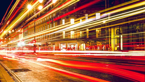 Traffic photographed at a slow shutter speed to create long motion blur, portraying fast movement.