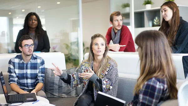 A creative team sitting in a relaxed meeting setting, discussing ideas and collaborating.