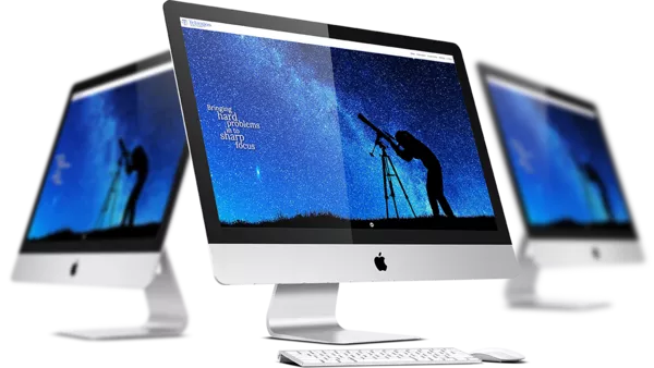 The Telaugos Solutions website on three iMacs.