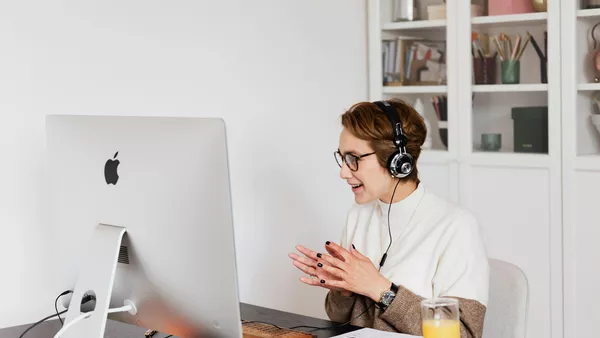 A woman on a video call at her desk.