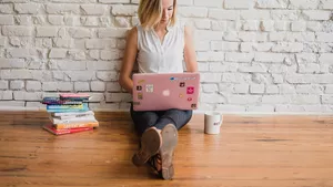 A woman sat on the floor with her laptop.