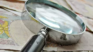 A magnifying glass laid on top of some money.