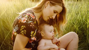 A mother and her baby outside on a warm sunny day.