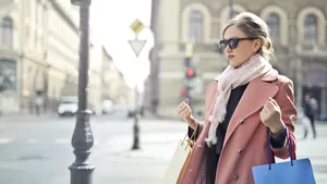 A woman with shopping bags on a busy high street.