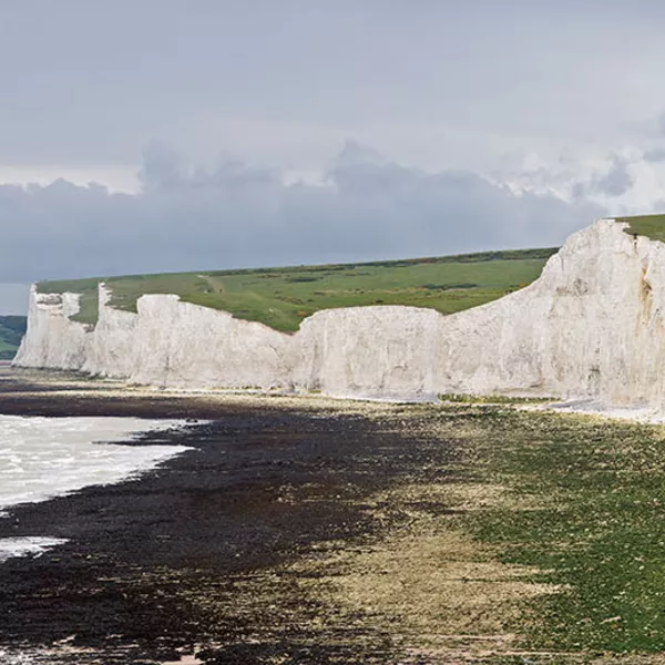The Seven Sisters, a series of seven chalk cliff peaks along the East Sussex coast in England. Seaford head in the background is on the other side of the River Cuckmere and not part of the Seven Sisters.